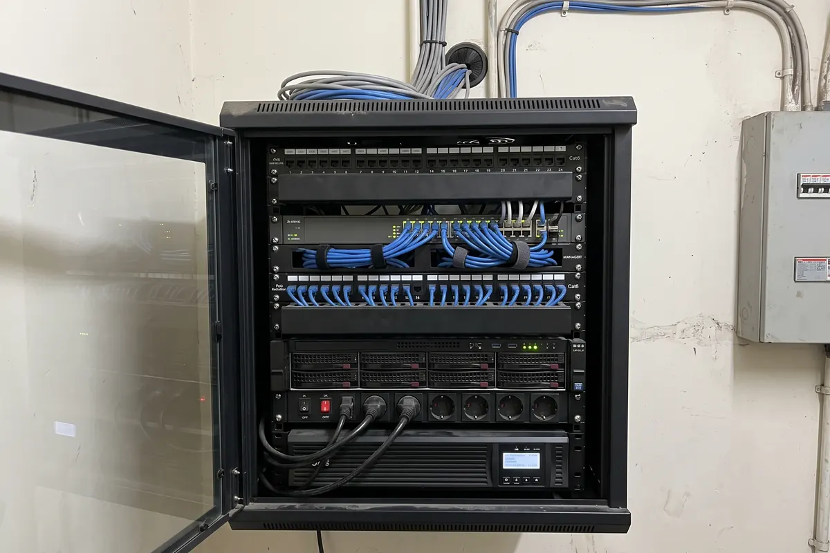 Wall-mount network rack with patch panels, PoE switch, velcro-dressed patch cords, NVR and UPS
